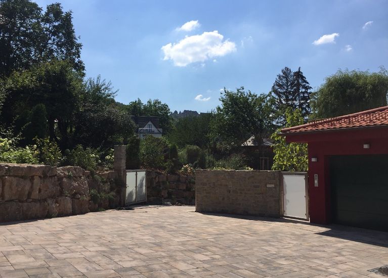 Garten­gestaltung mit Mauern und Belegs­flächen aus Naturstein in