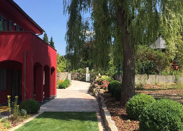 Garten­gestaltung mit Mauern und Belegs­flächen aus Naturstein in